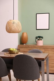 Photo of Wooden table with chairs and apples in dining room. Interior design