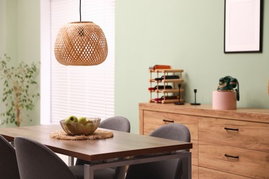 Photo of Wooden table with chairs and apples in dining room. Interior design