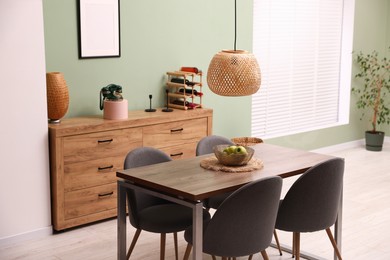 Photo of Wooden table with chairs and apples in dining room. Interior design