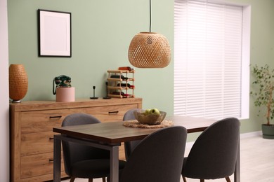 Photo of Wooden table with chairs and apples in dining room. Interior design