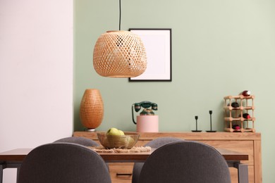 Photo of Wooden table with chairs and apples in dining room. Interior design