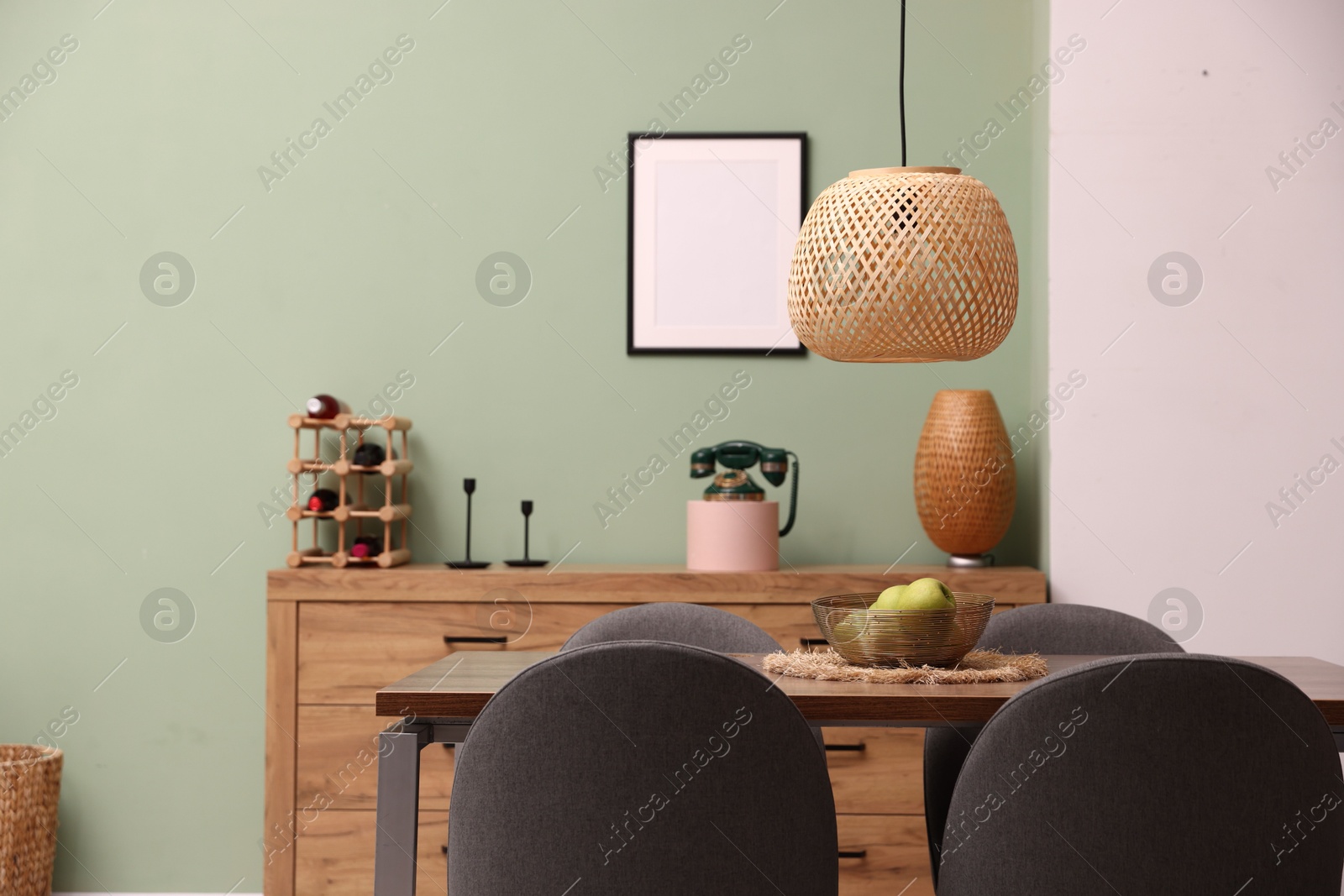 Photo of Wooden table with chairs and apples in dining room. Interior design