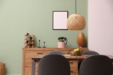 Photo of Wooden table with chairs and apples in dining room. Interior design