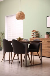 Photo of Wooden table with chairs and apples in dining room. Interior design