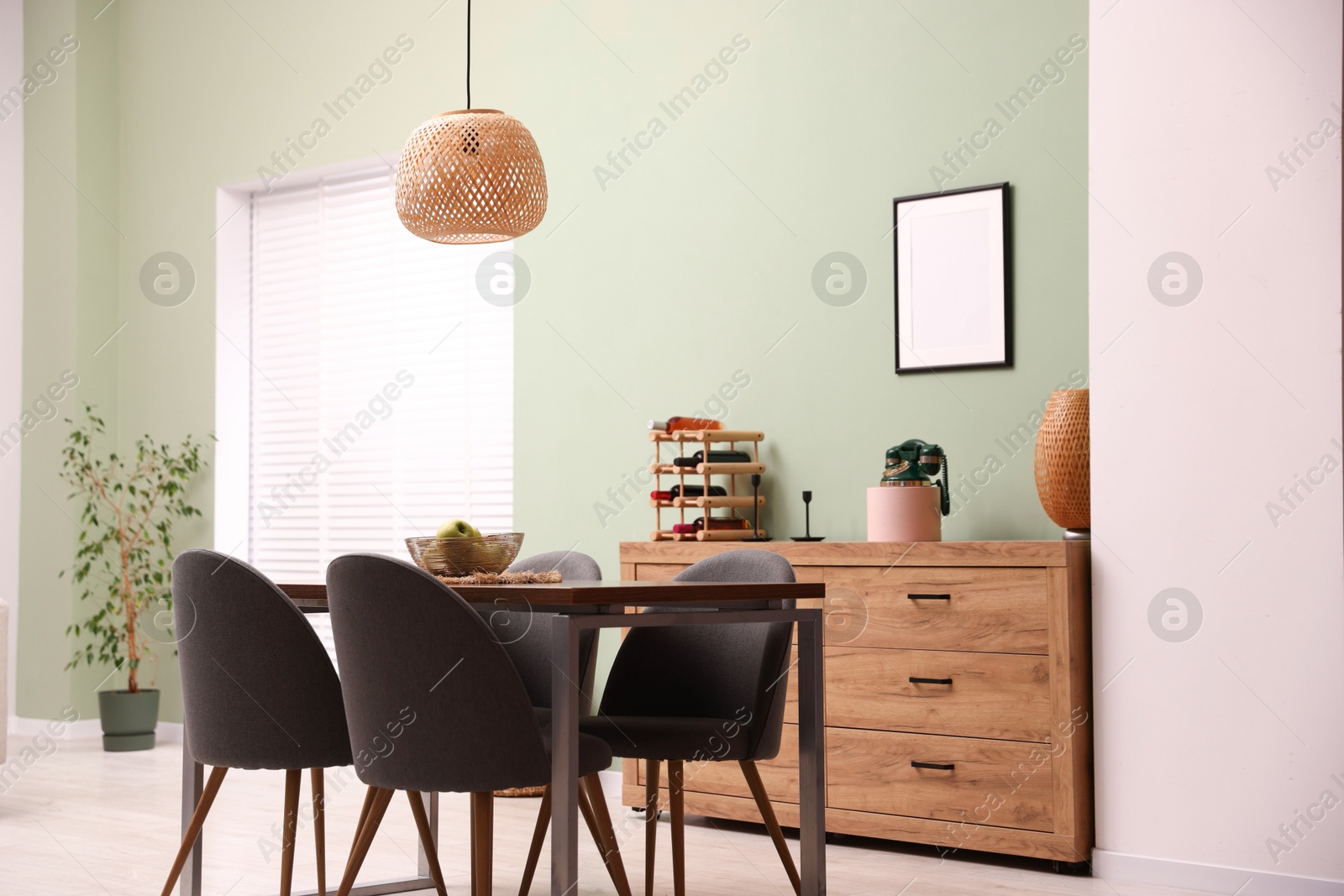 Photo of Wooden table with chairs and apples in dining room. Interior design