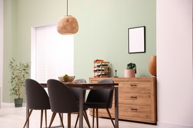 Photo of Wooden table with chairs and apples in dining room. Interior design