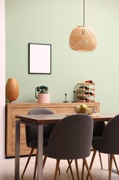 Photo of Wooden table with chairs and apples in dining room. Interior design