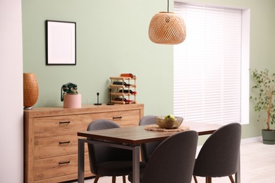 Photo of Wooden table with chairs and apples in dining room. Interior design