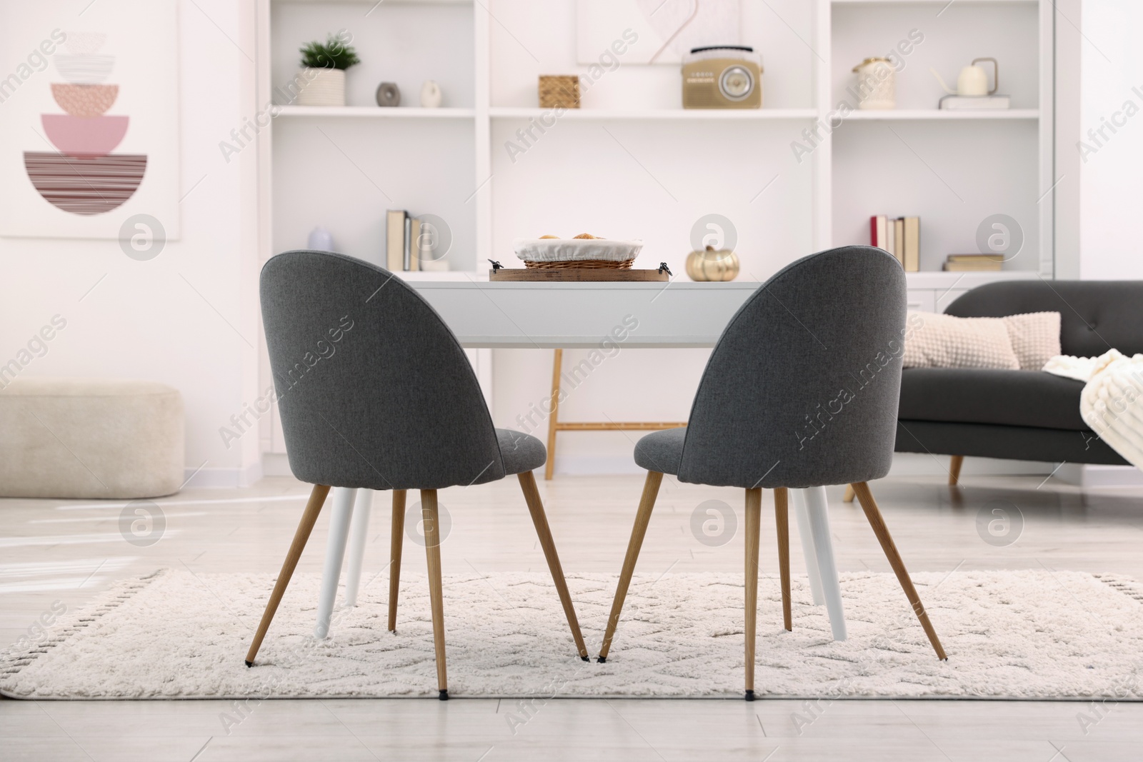 White table with chairs and decor in stylish dining room. Interior design Photo of White table with chairs and decor in stylish dining room. Interior design