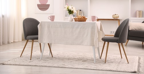 Photo of Stylish table with chairs and decor in dining room. Interior design