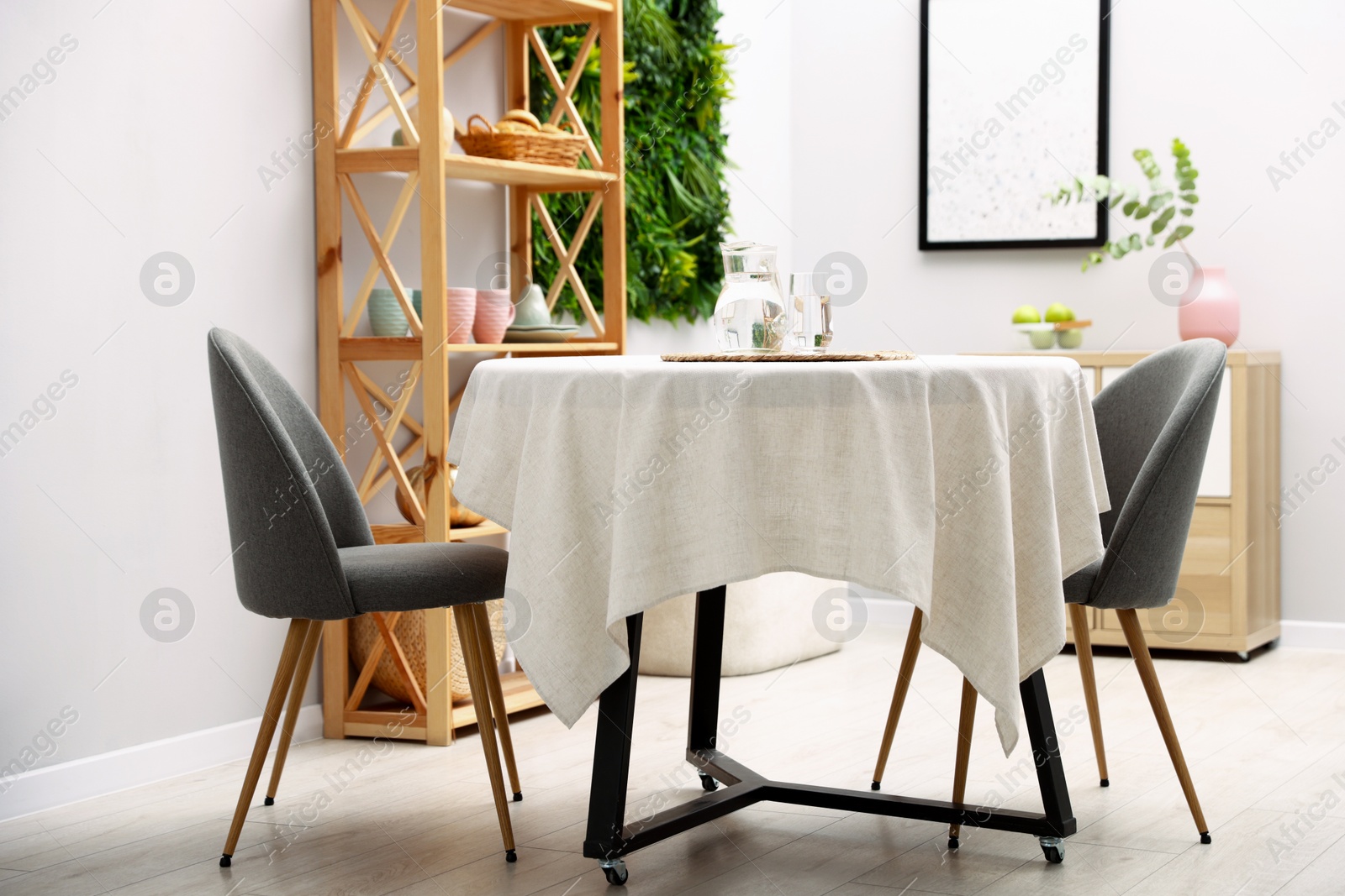 Photo of Stylish table with chairs and decor in dining room. Interior design