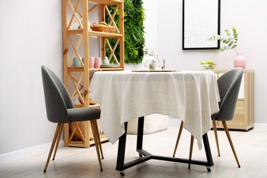 Photo of Stylish table with chairs and decor in dining room. Interior design