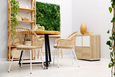 Photo of Wooden table with chairs and decor in stylish dining room. Interior design