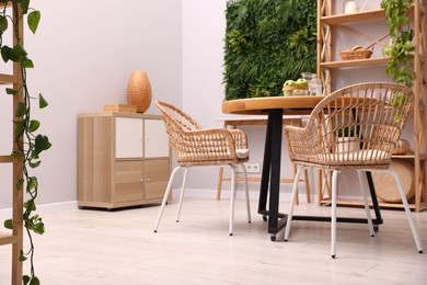 Photo of Wooden table with chairs and decor in stylish dining room. Interior design