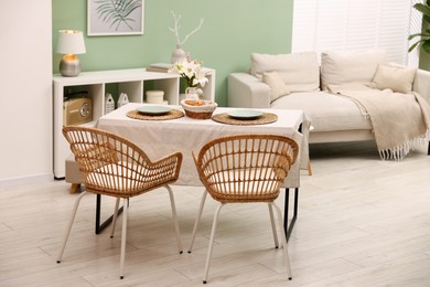Photo of Stylish table with chairs and decor in dining room. Interior design