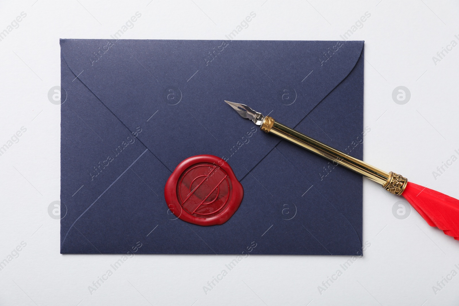 Envelope with wax seal and fountain pen on white background, top view Photo of Envelope with wax seal and fountain pen on white background, top view