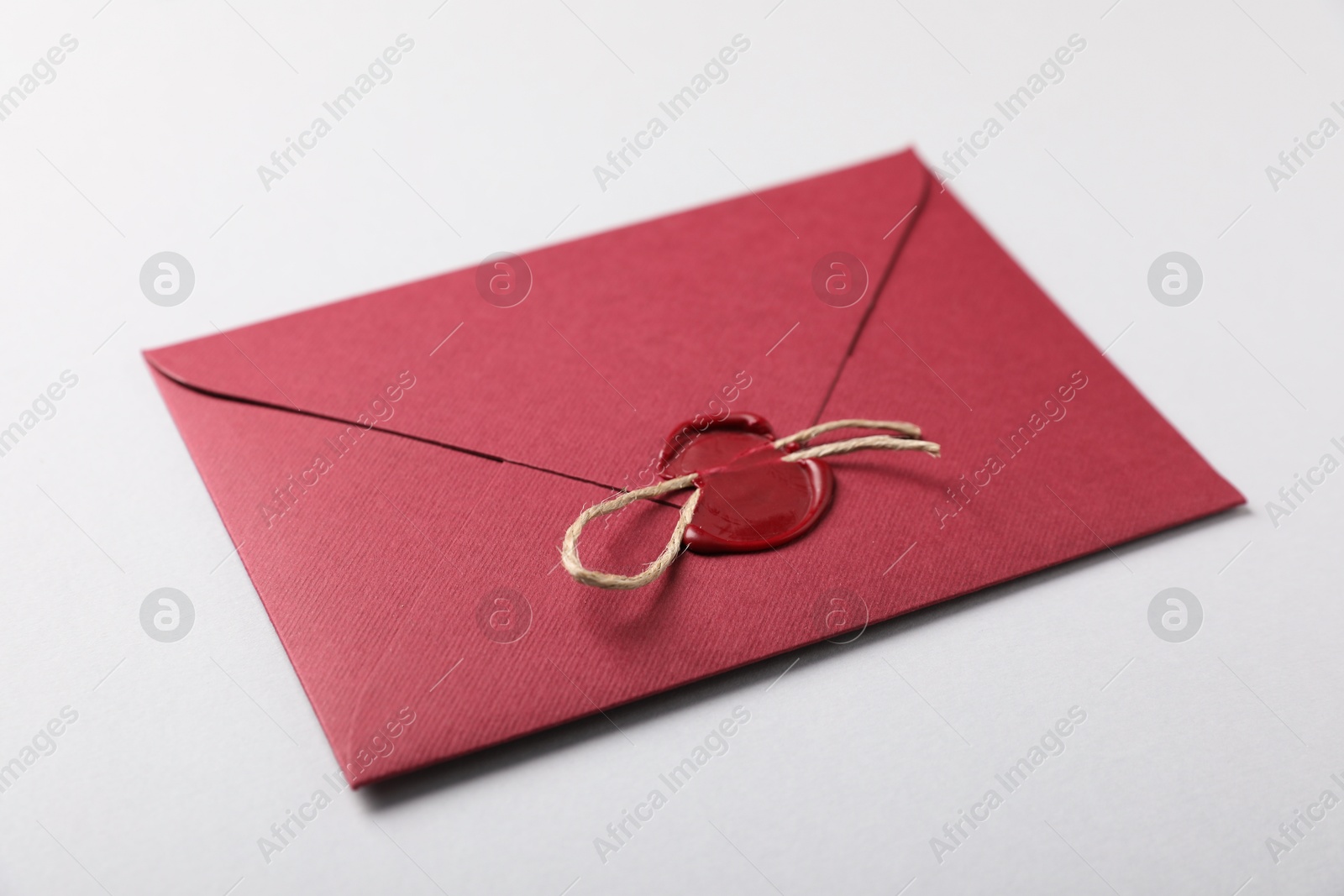 Envelope with wax seal and twine on white background, closeup Photo of Envelope with wax seal and twine on white background, closeup