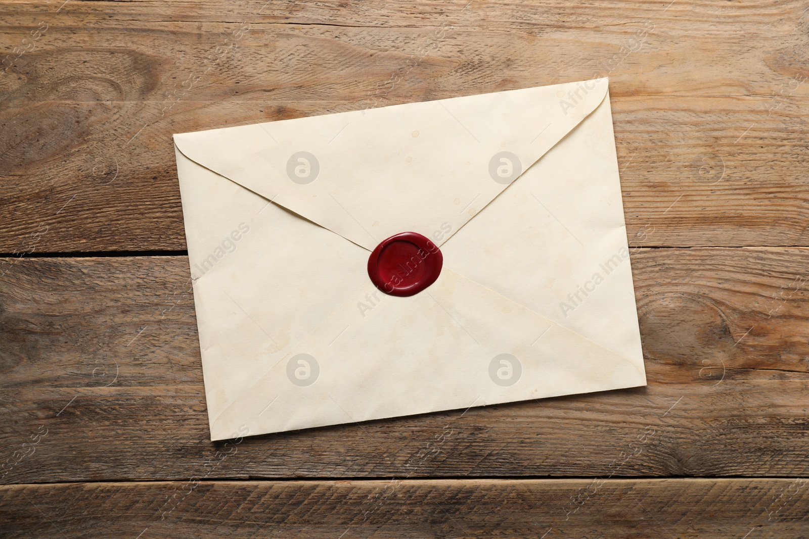 Envelope with wax seal on wooden table, top view Photo of Envelope with wax seal on wooden table, top view