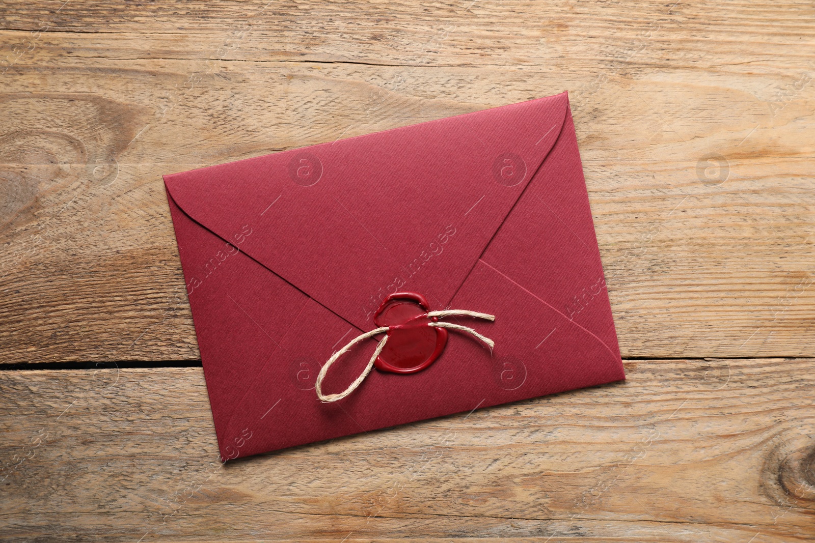 Envelope with wax seal and twine on wooden table, top view Photo of Envelope with wax seal and twine on wooden table, top view