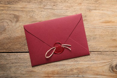 Photo of Envelope with wax seal and twine on wooden table, top view