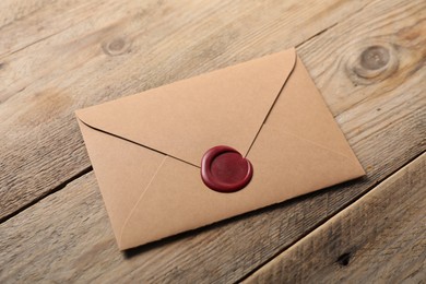 Photo of Envelope with wax seal on wooden table, above view