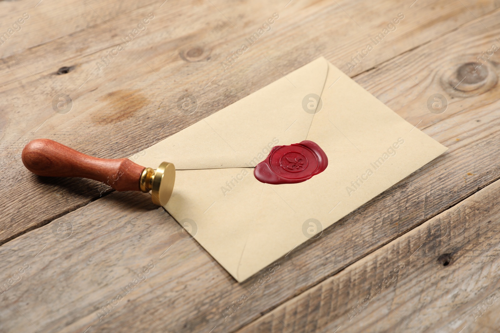 Envelope with wax seal and stamp on wooden table, closeup Photo of Envelope with wax seal and stamp on wooden table, closeup