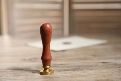 Photo of Wax stamp on wooden table, closeup. Space for text