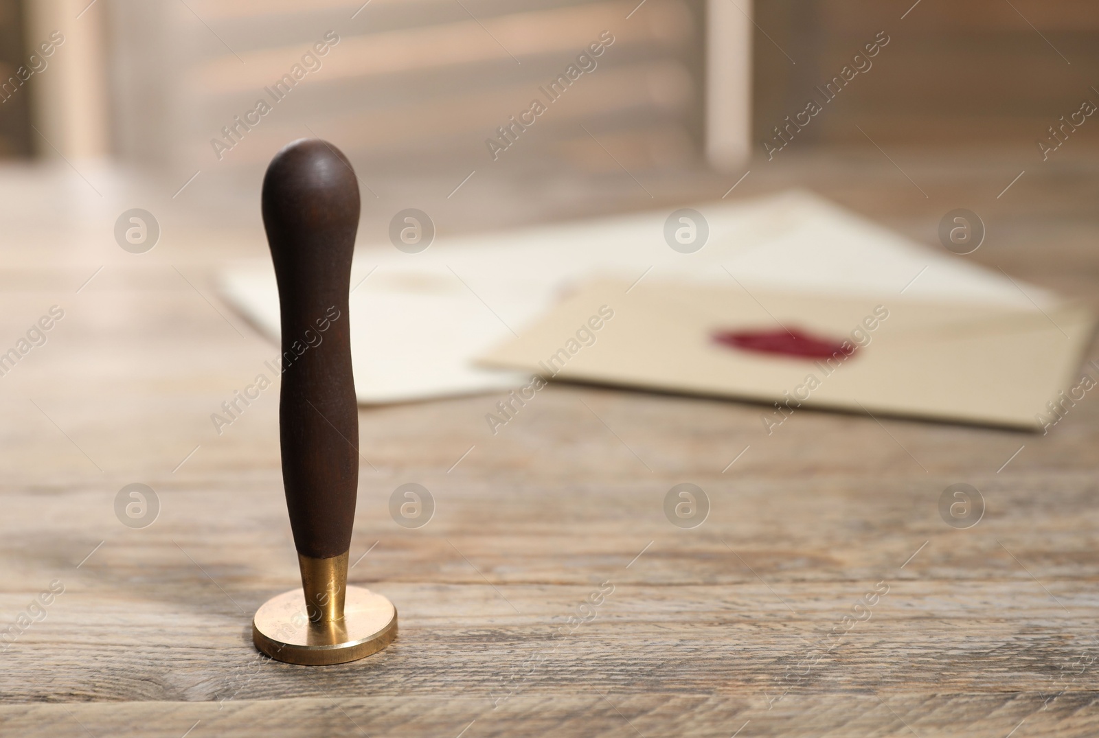 Wax stamp and envelopes on wooden table, closeup. Space for text Photo of Wax stamp and envelopes on wooden table, closeup. Space for text