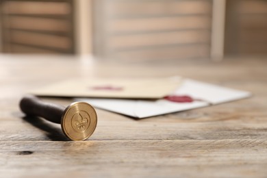 Photo of Wax stamp and envelopes on wooden table, closeup. Space for text