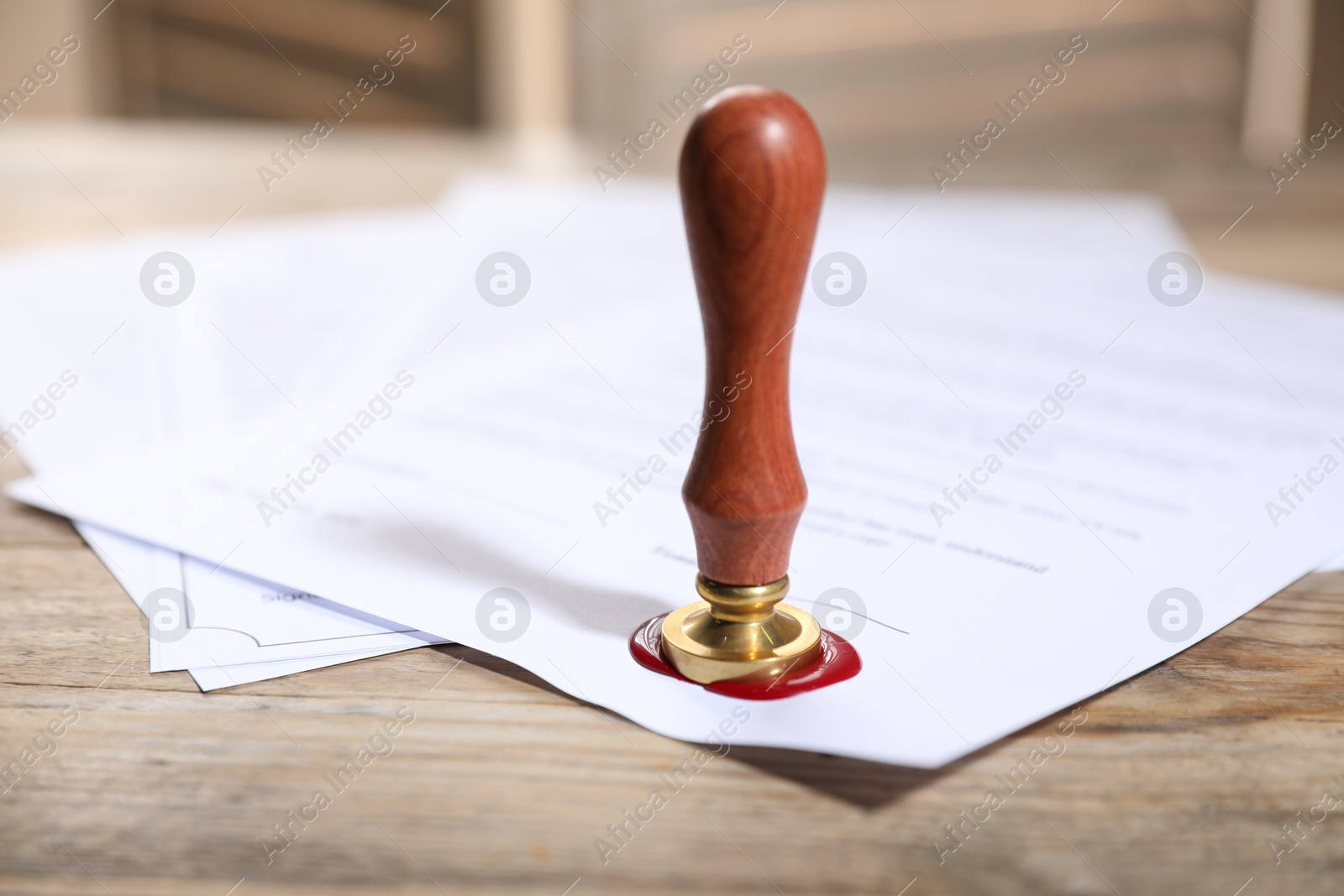 Documents with wax seal and stamp on wooden table, closeup Photo of Documents with wax seal and stamp on wooden table, closeup