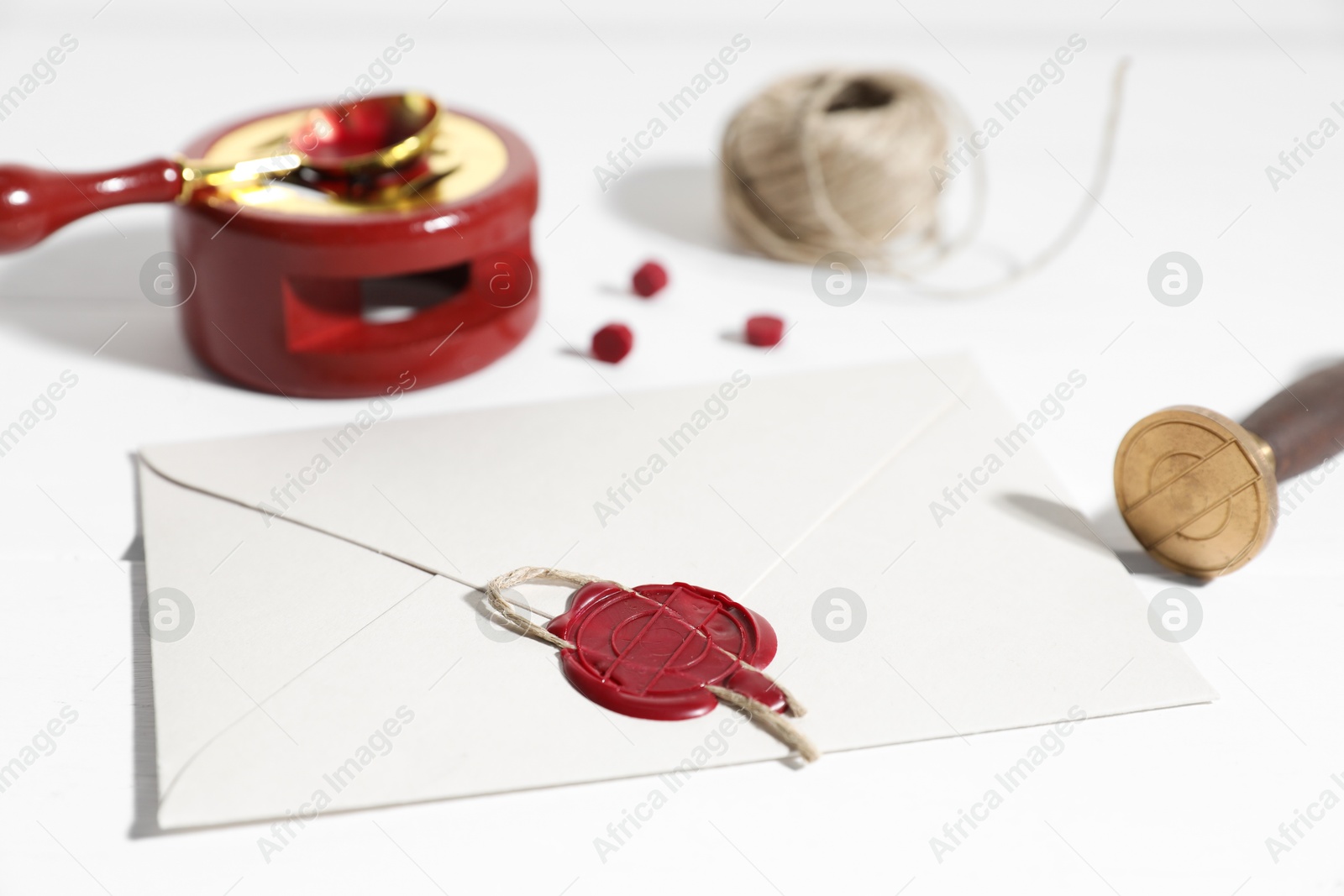Envelope with wax seal and stamp on white wooden table, closeup Photo of Envelope with wax seal and stamp on white wooden table, closeup