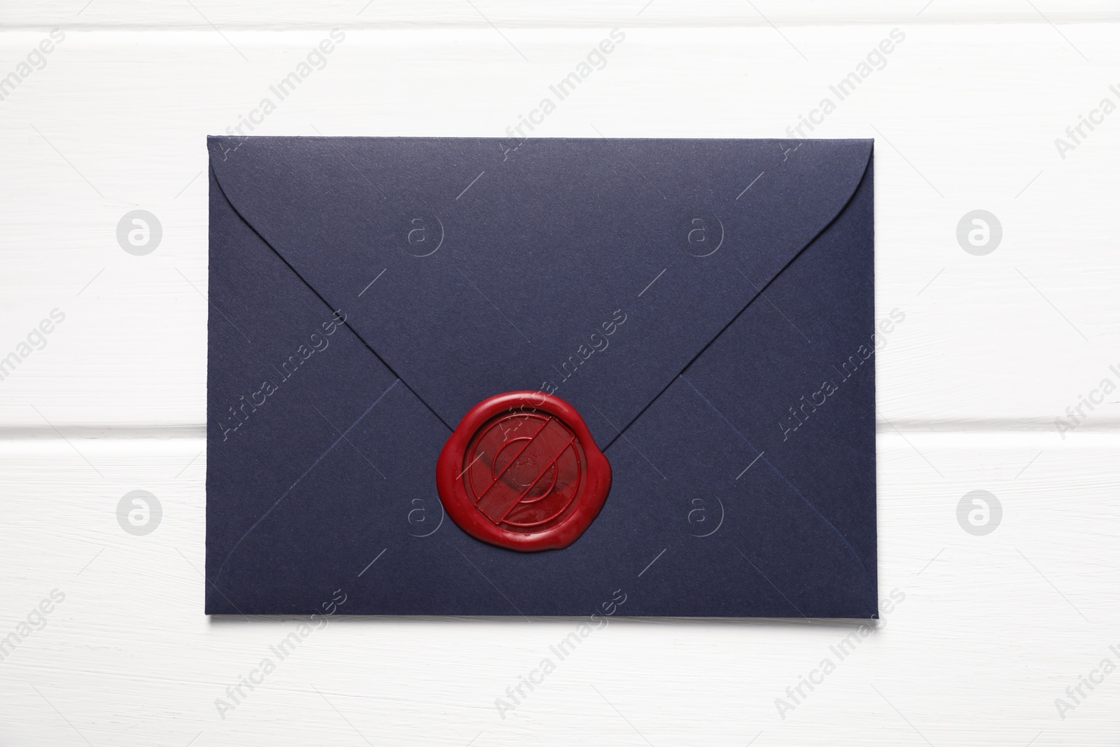 Envelope with wax seal on white wooden table, top view Photo of Envelope with wax seal on white wooden table, top view