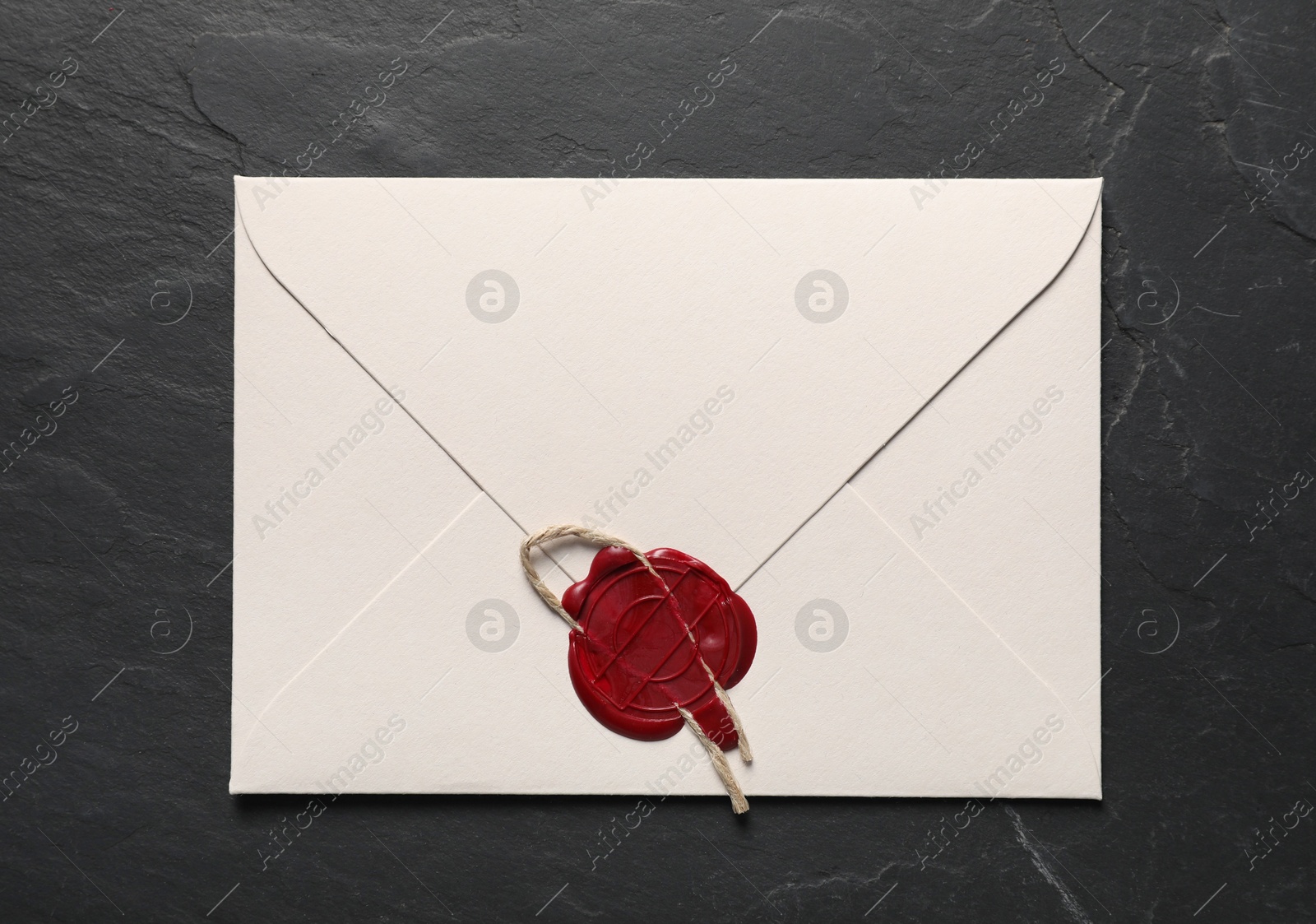 Envelope with wax seal and twine on black table, top view Photo of Envelope with wax seal and twine on black table, top view