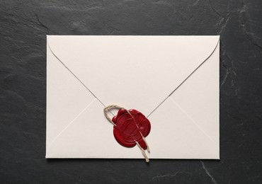 Photo of Envelope with wax seal and twine on black table, top view