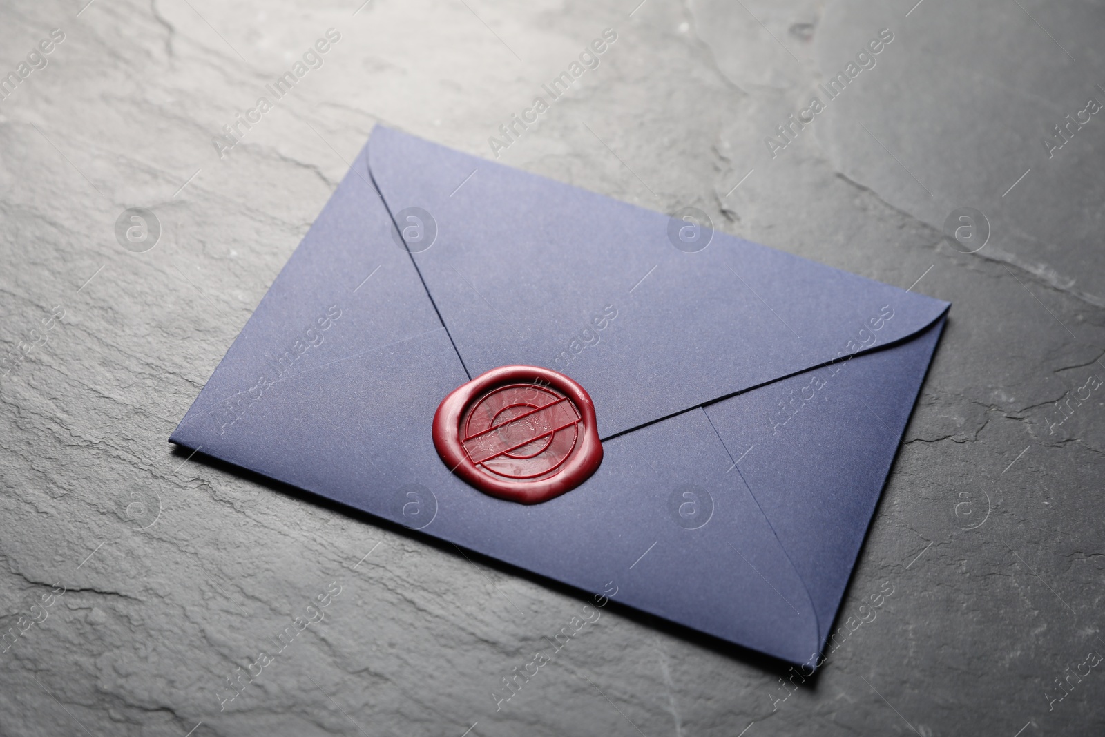 Envelope with wax seal on black table, closeup Photo of Envelope with wax seal on black table, closeup