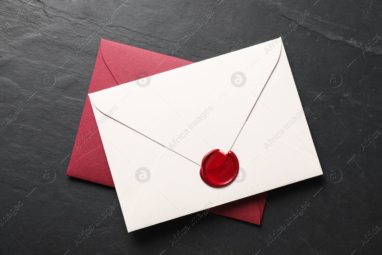 Envelopes with wax seal on black table, top view Photo of Envelopes with wax seal on black table, top view
