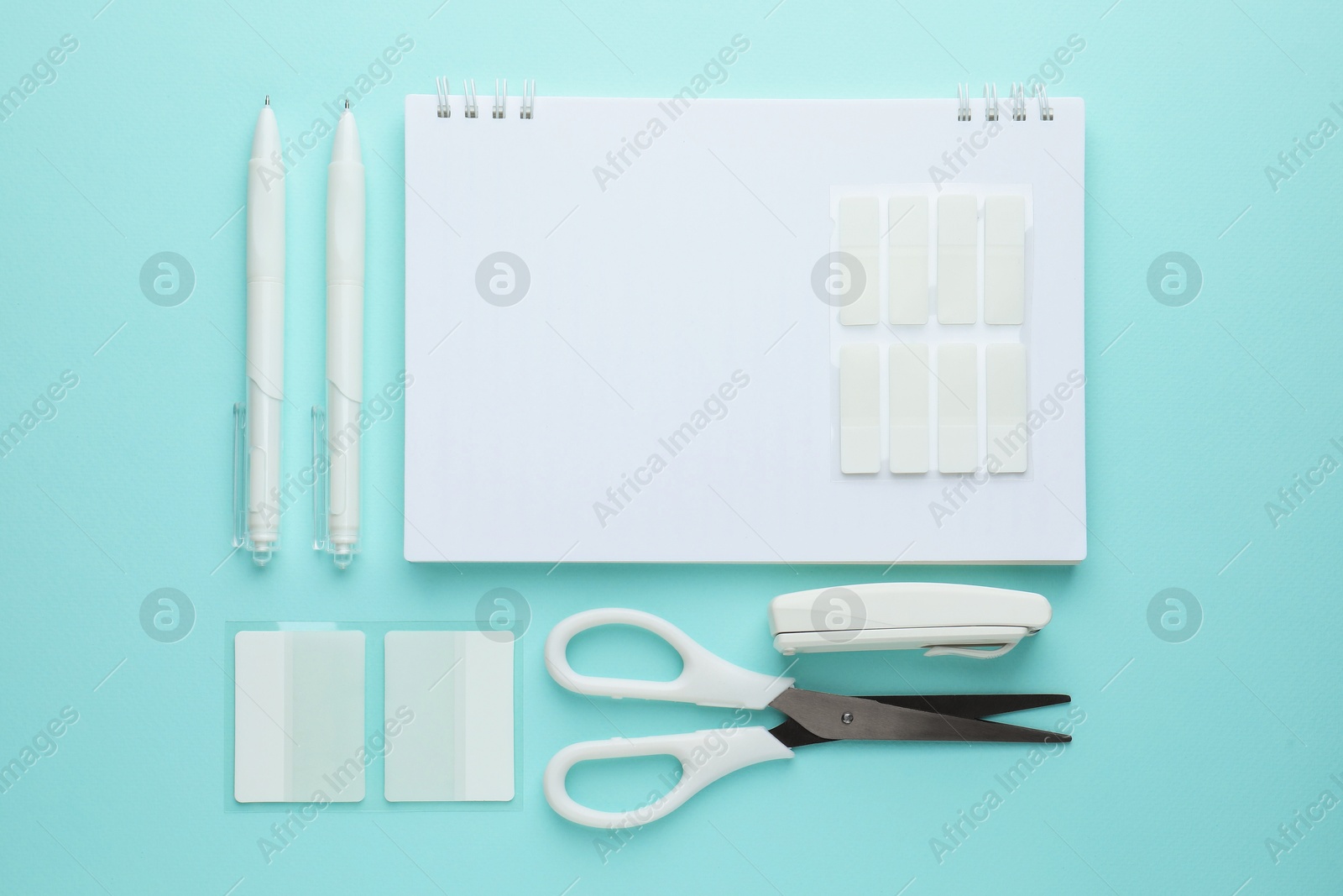 White notebook and other stationery on light blue background, flat lay Photo of White notebook and other stationery on light blue background, flat lay