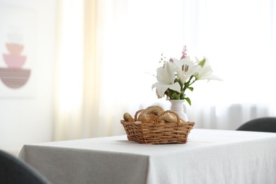Photo of Stylish table with pastries and flowers in dining room. Interior design