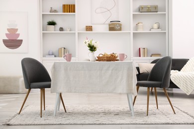 Photo of Stylish table with chairs and decor in dining room. Interior design