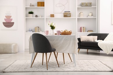 Photo of Stylish table with chairs and decor in dining room. Interior design