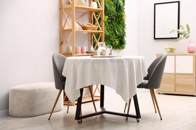 Photo of Stylish table with chairs and decor in dining room. Interior design