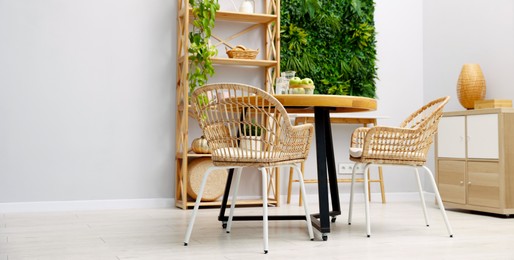 Photo of Wooden table with chairs and decor in stylish dining room, space for text. Interior design