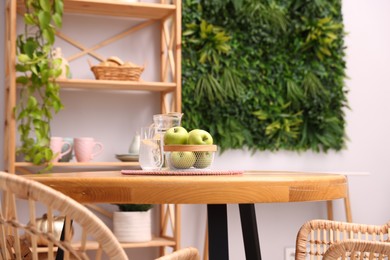Photo of Wooden table with chairs and decor in stylish dining room, closeup. Interior design