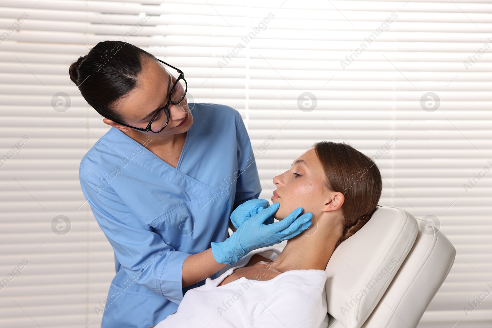 Doctor examining young woman's mole in hospital Photo of Doctor examining young woman's mole in hospital