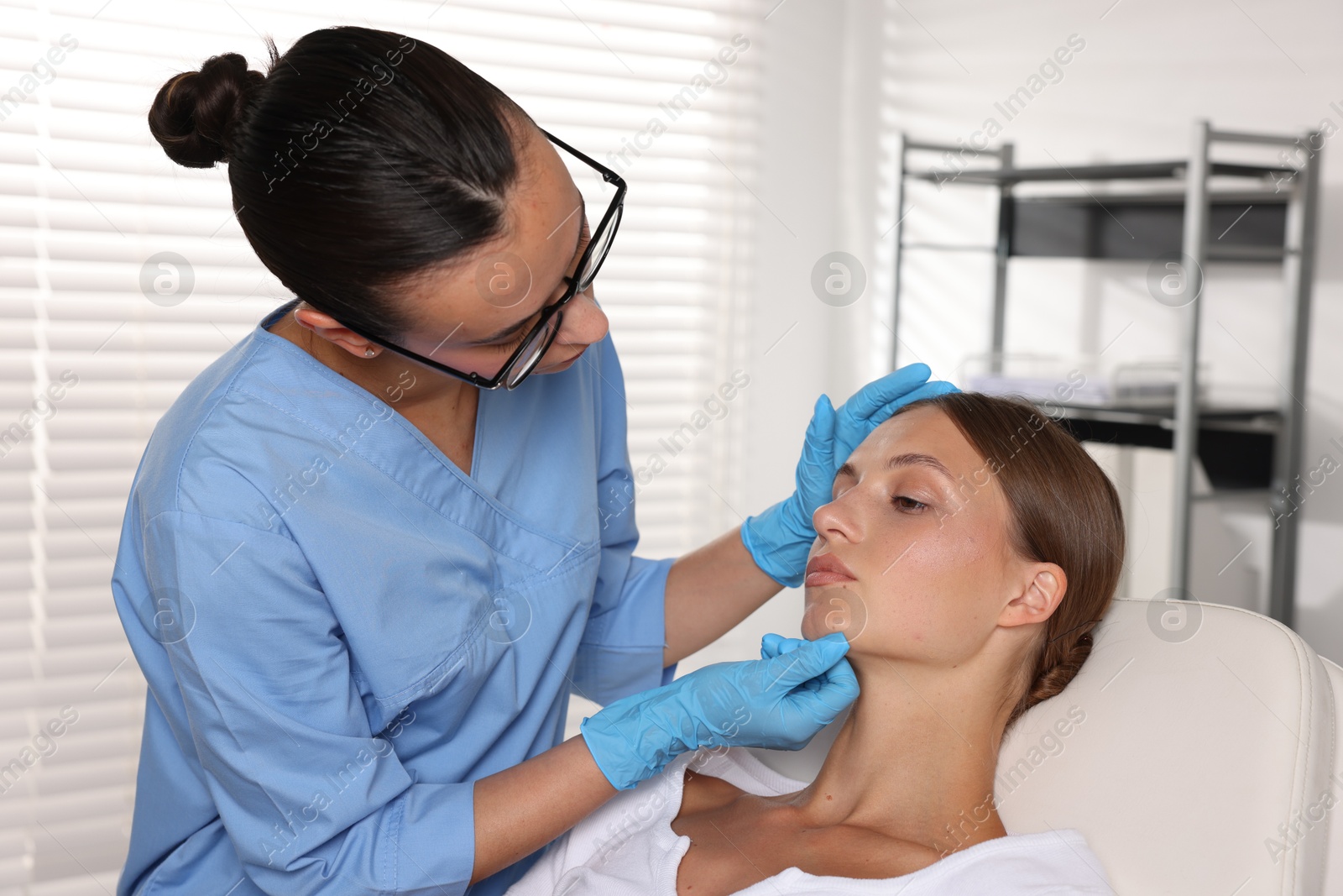 Doctor examining young woman's mole in hospital Photo of Doctor examining young woman's mole in hospital