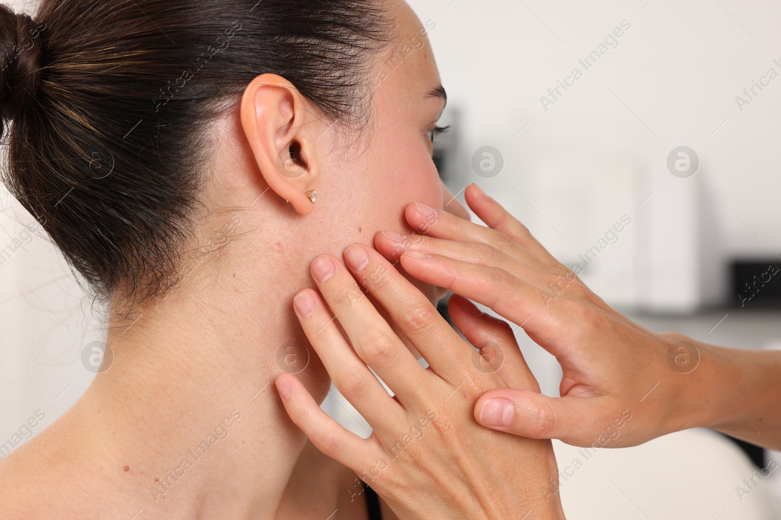 Doctor examining young woman's mole in hospital, closeup Photo of Doctor examining young woman's mole in hospital, closeup