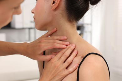 Photo of Doctor examining young woman's mole in hospital, closeup