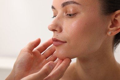 Photo of Doctor examining young woman's mole in hospital, closeup