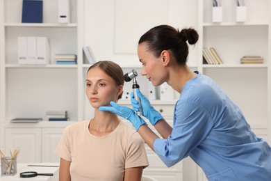 Photo of Doctor examining young woman's mole with dermatoscope in hospital