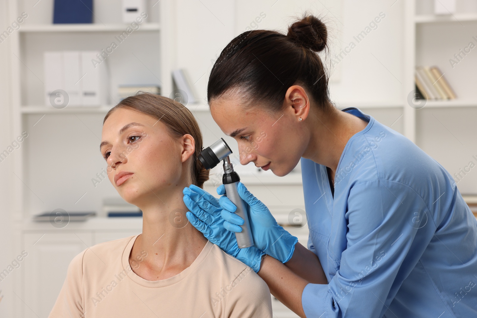 Photo of Doctor examining young woman's mole with dermatoscope in hospital